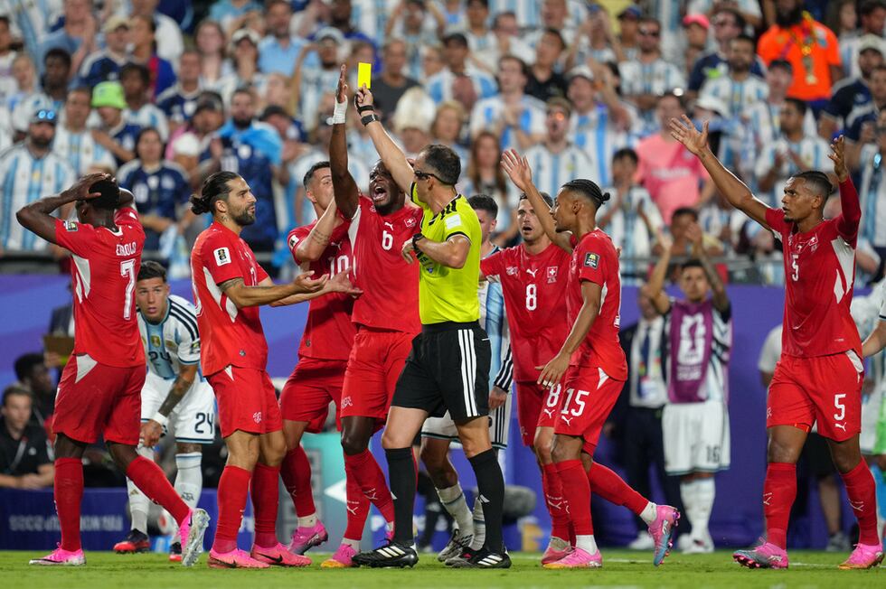 Los jugadores de Suiza discuten con el árbitro portugués Joao Pinheiro, quien muestra una...