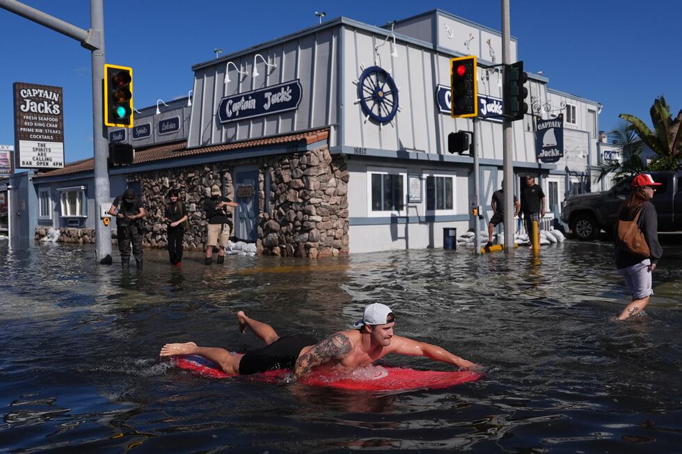 Un hombre surfea en una inundación, el miércoles 28 de octubre de 2026, en Huntington Beach,...